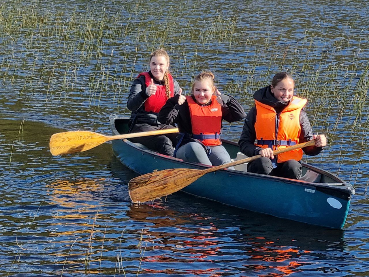 Tre jenter i ein kano